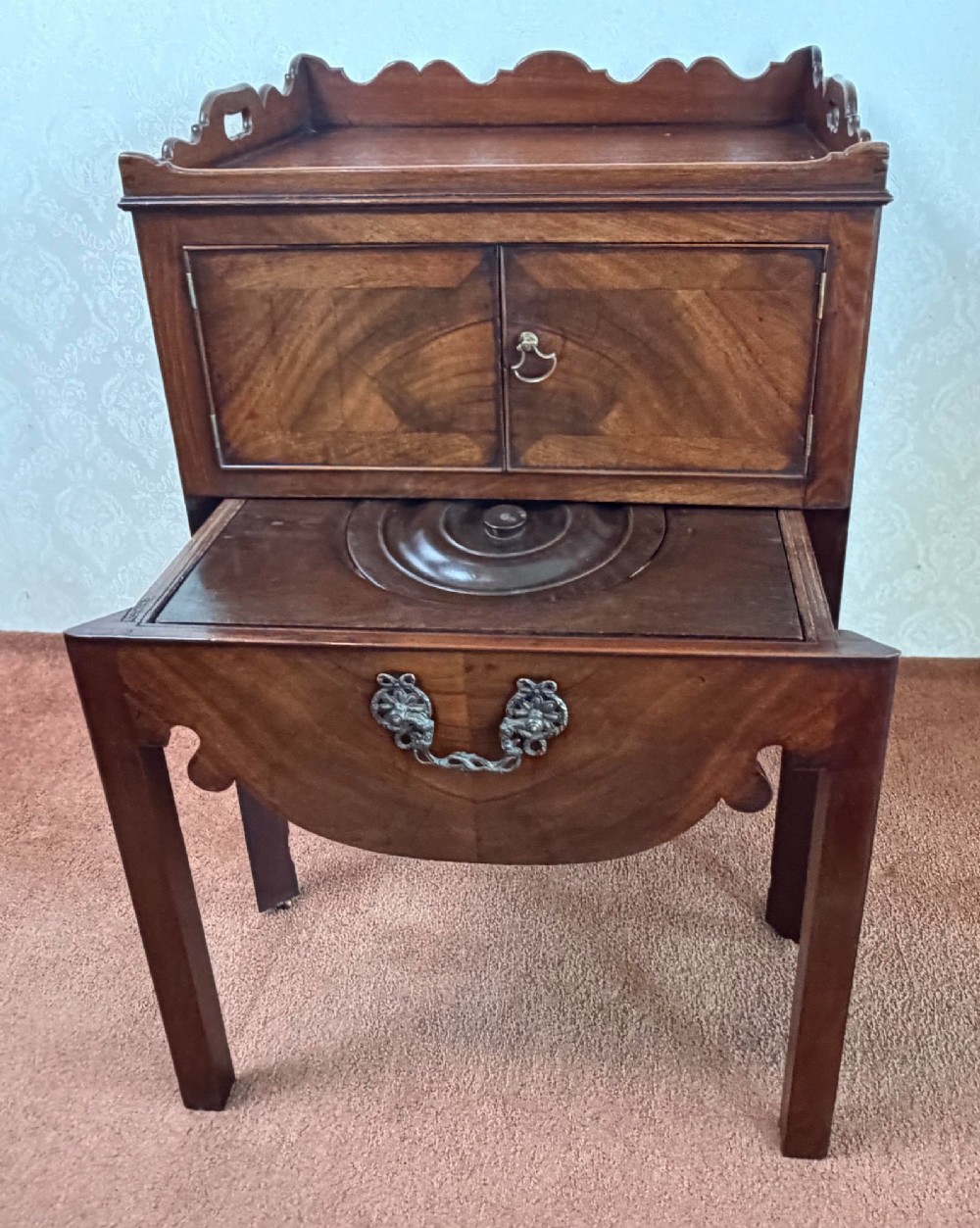 Mid-18th century Georgian mahogany bedside cabinet featuring a tray top gallery with cut-out handholds, double cupboard doors, lower drawer, and square legs. View V
