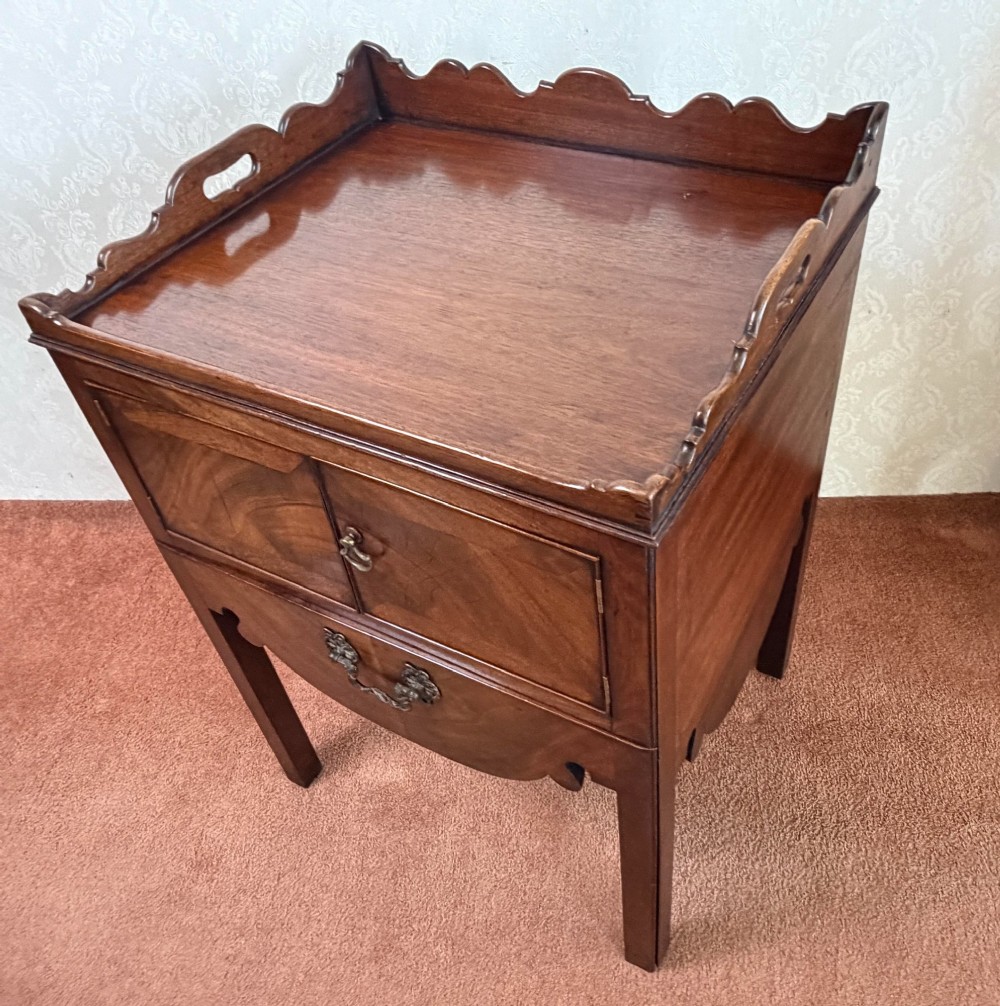 Mid-18th century Georgian mahogany bedside cabinet featuring a tray top gallery with cut-out handholds, double cupboard doors, lower drawer, and square legs. View VI