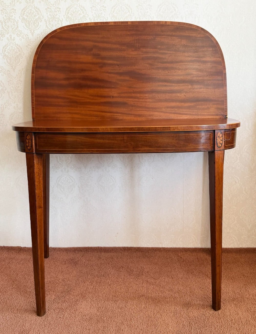 A Sheraton period mahogany tea table with a semi-circular folding top, string inlay along the apron, and slender square tapered legs. View III