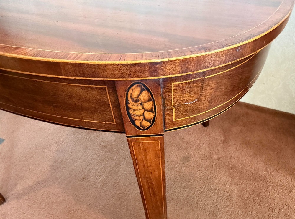 A Sheraton period mahogany tea table with a semi-circular folding top, string inlay along the apron, and slender square tapered legs. View V