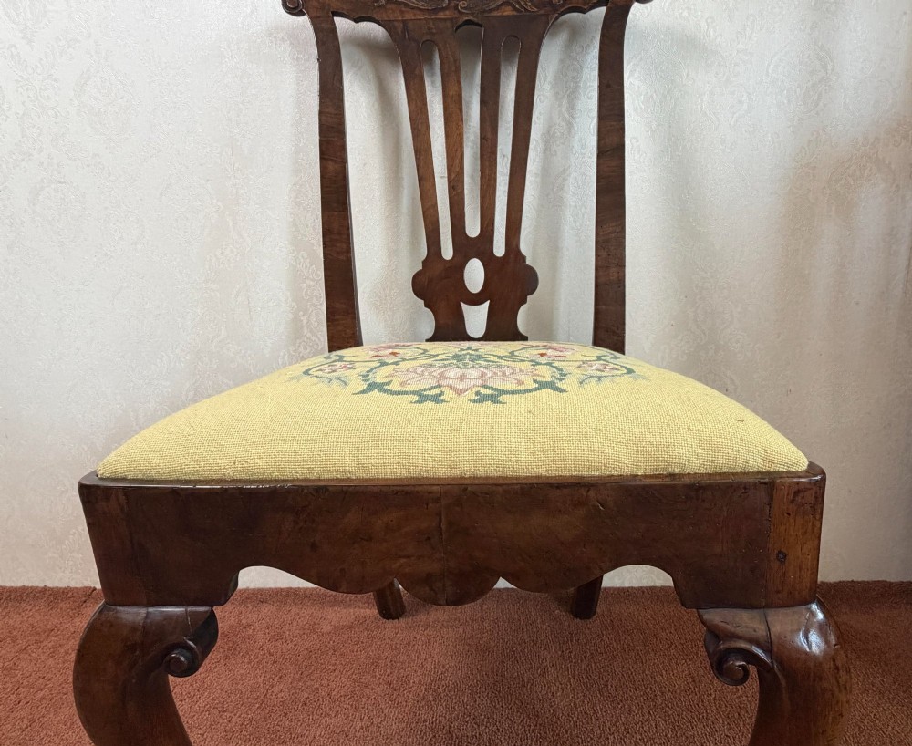 An early 18th-century walnut side chair featuring a carved pierced splat back, shaped apron, cabriole front legs, and an embroidered drop-in seat pad. View II