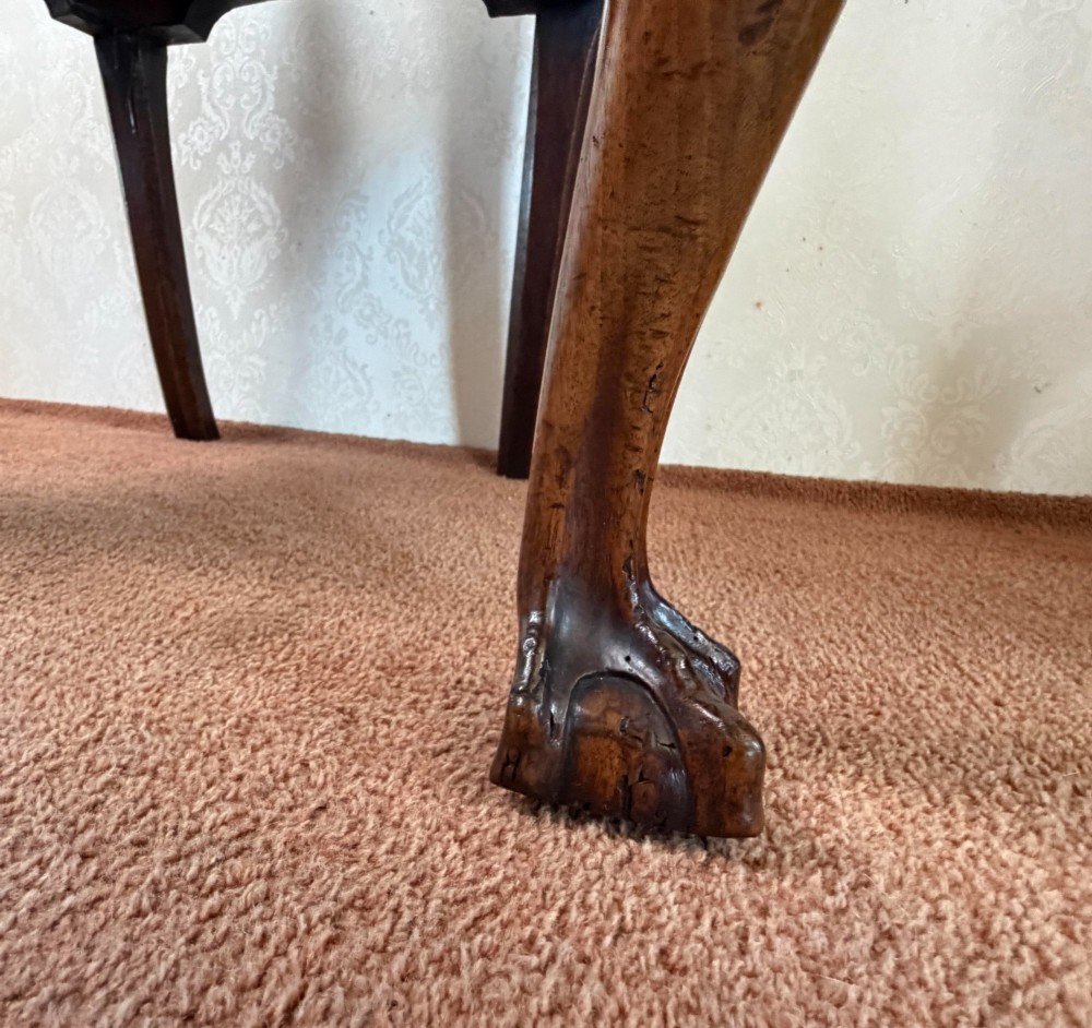 An early 18th-century walnut side chair featuring a carved pierced splat back, shaped apron, cabriole front legs, and an embroidered drop-in seat pad. View IV