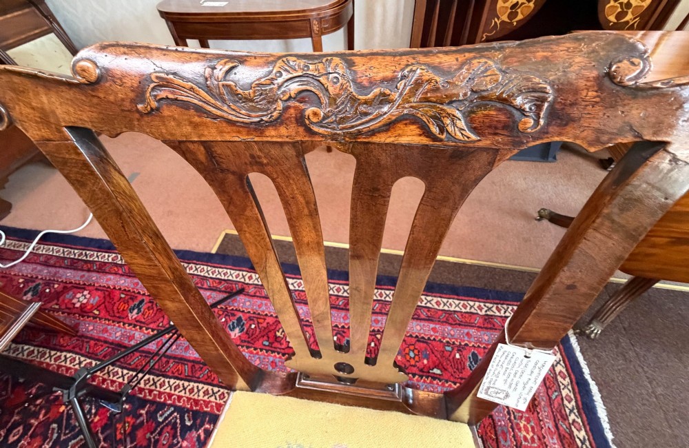 An early 18th-century walnut side chair featuring a carved pierced splat back, shaped apron, cabriole front legs, and an embroidered drop-in seat pad. View VII