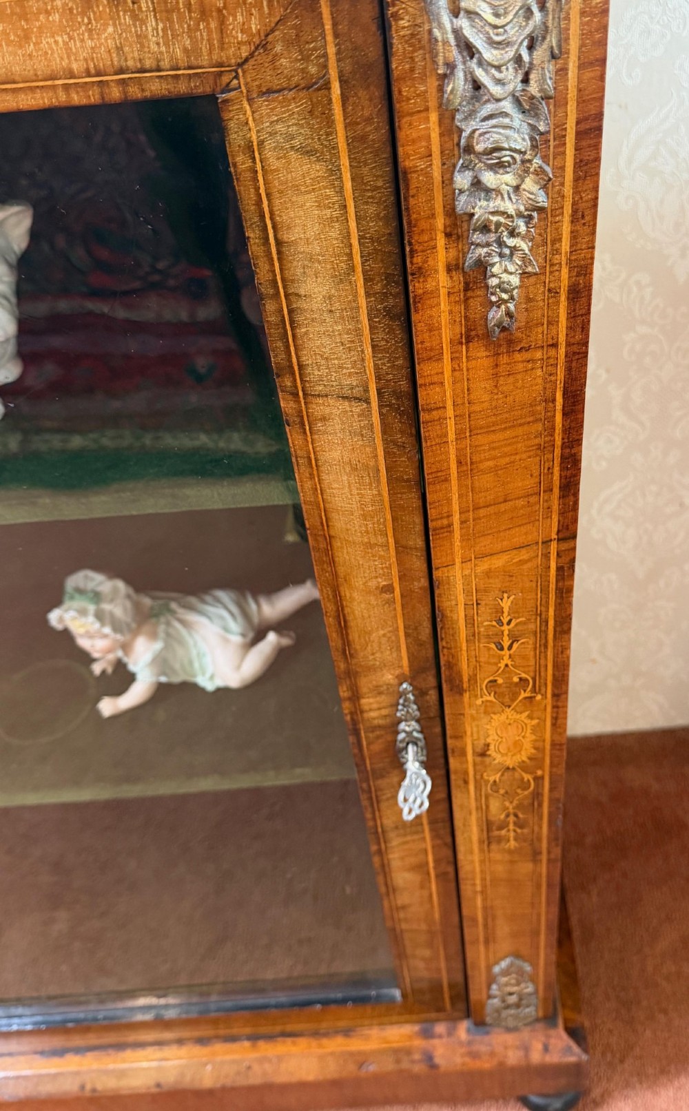 A Victorian burr walnut pier cabinet with floral marquetry inlay, ornate gilt brass mounts, and a single glazed door disclosing velvet-lined shelving. View IV