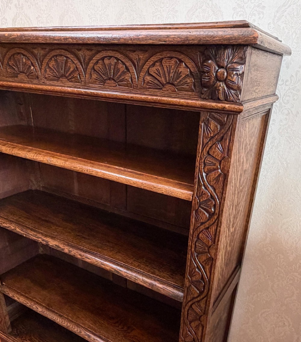 Late 19th-century dark oak open bookcase featuring hand-carved floral stiles, a lunette frieze, and four open shelves. View II