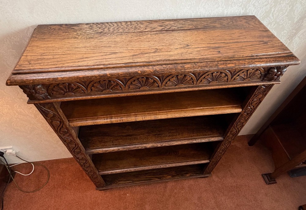 Late 19th-century dark oak open bookcase featuring hand-carved floral stiles, a lunette frieze, and four open shelves. View III