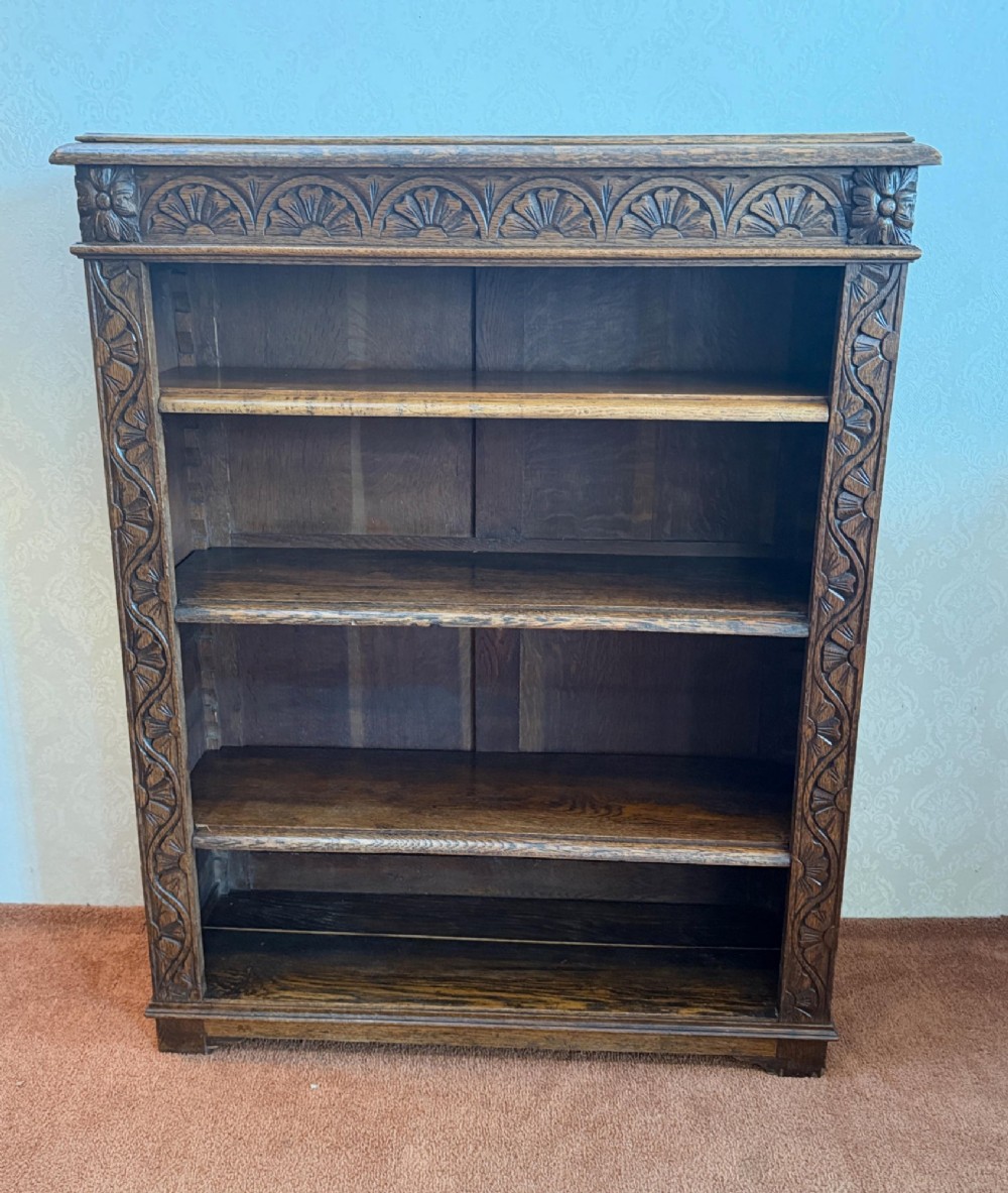 Late 19th-century dark oak open bookcase featuring hand-carved floral stiles, a lunette frieze, and four open shelves. View IV