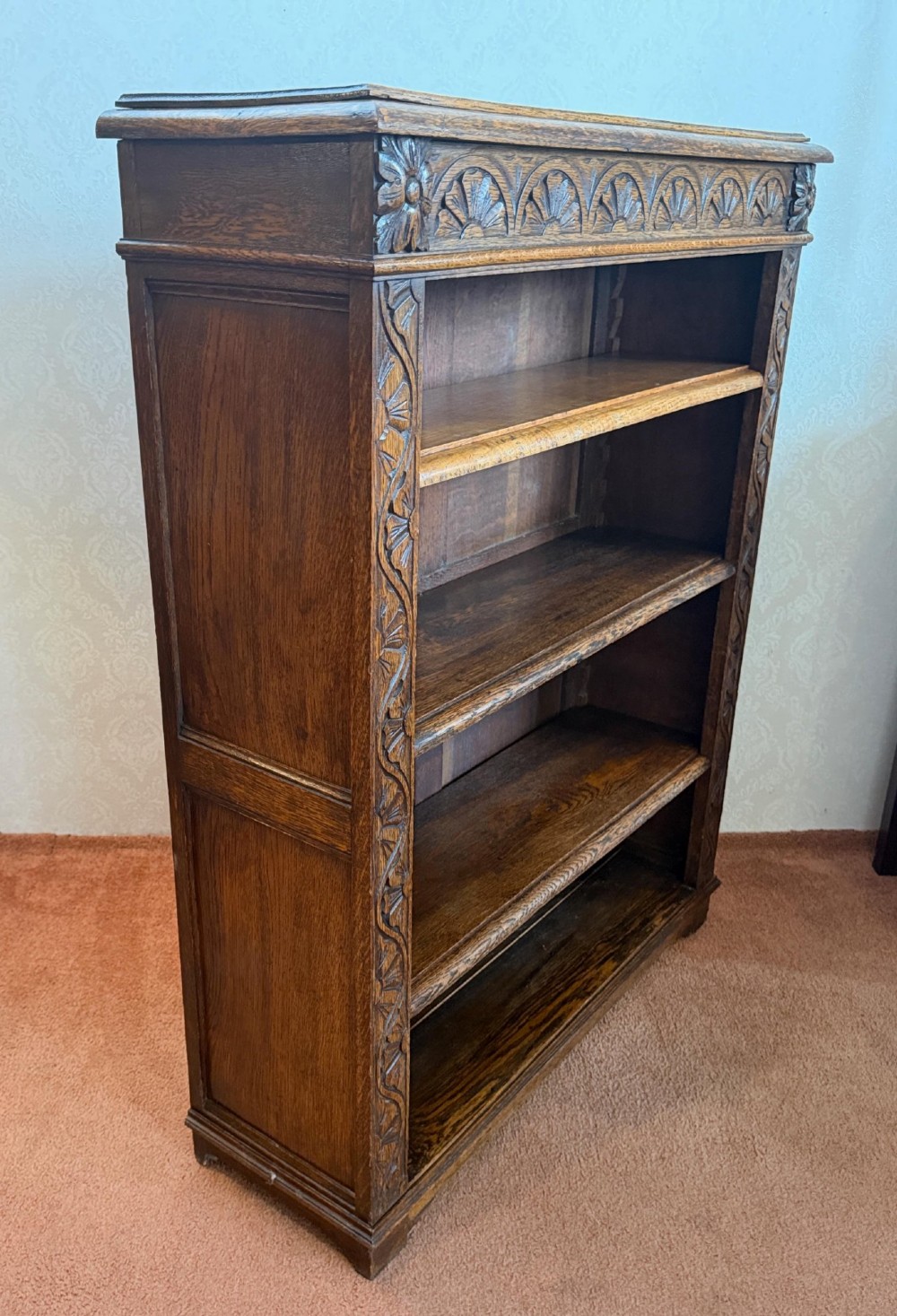 Late 19th-century dark oak open bookcase featuring hand-carved floral stiles, a lunette frieze, and four open shelves. View V