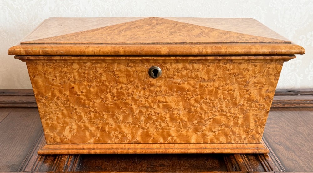 An early nineteenth-century William IV birdseye maple tea caddy featuring a faceted lid and brass keyhole escutcheon. View II