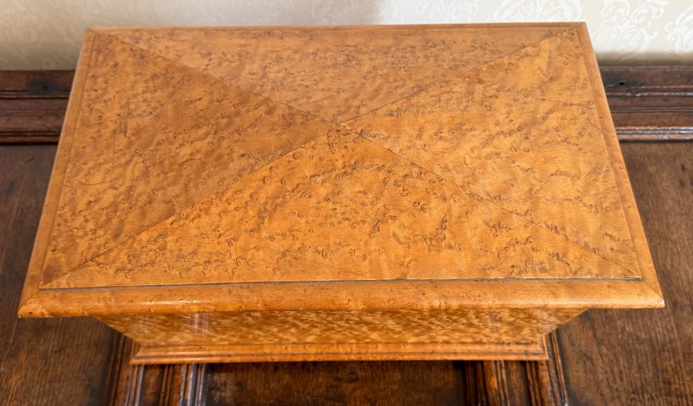 An early nineteenth-century William IV birdseye maple tea caddy featuring a faceted lid and brass keyhole escutcheon. View III