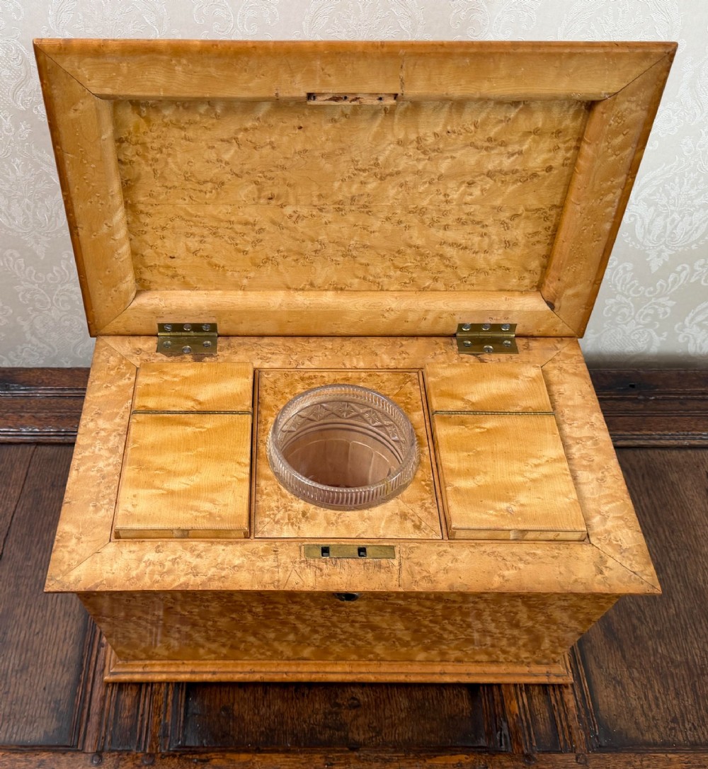 An early nineteenth-century William IV birdseye maple tea caddy featuring a faceted lid and brass keyhole escutcheon. View V