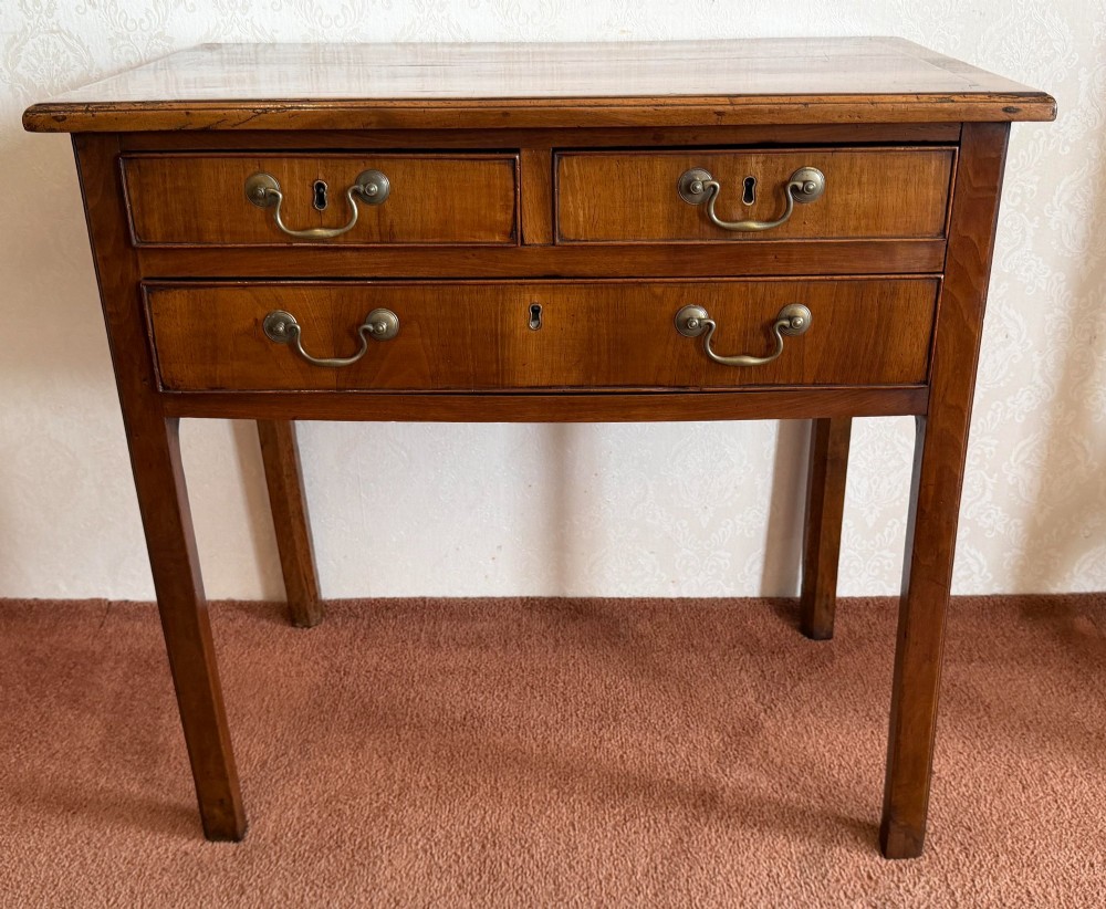 An antique English walnut lowboy featuring two small upper drawers above one long drawer, mounted with brass drop handles on four legs. View II