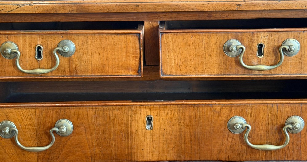 An antique English walnut lowboy featuring two small upper drawers above one long drawer, mounted with brass drop handles on four legs. View IV