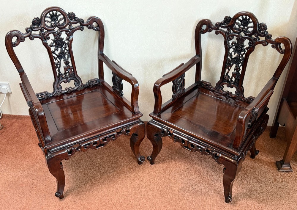 A pair of dark polished hardwood armchairs featuring intricate openwork floral carvings on the splat and decorative carved aprons. View VI