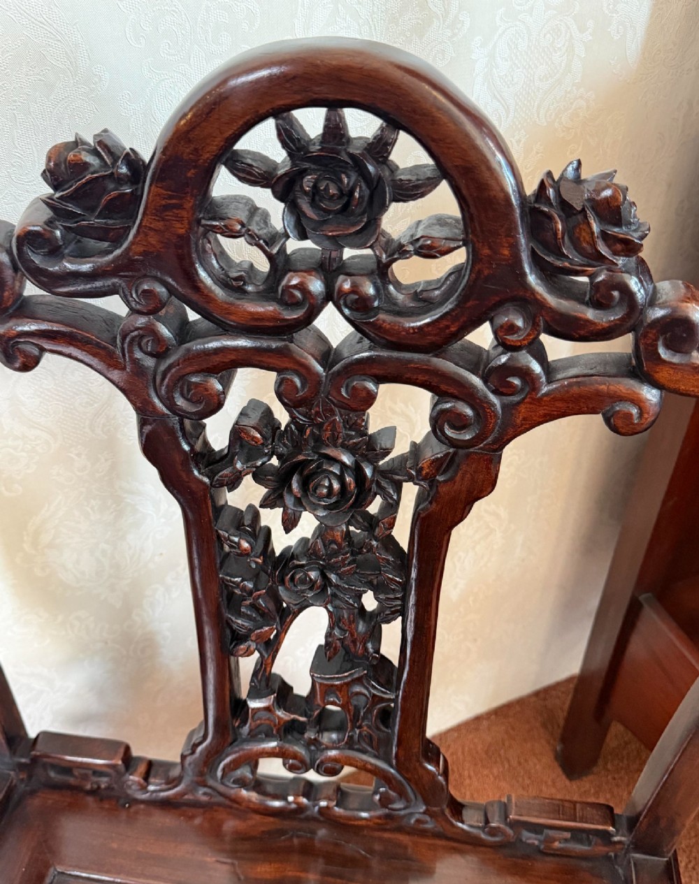 A pair of dark polished hardwood armchairs featuring intricate openwork floral carvings on the splat and decorative carved aprons. View VIII