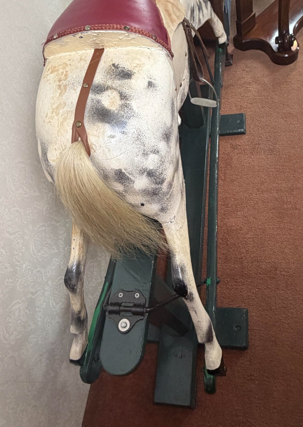 A 19th-century carved wooden dappled grey rocking horse with a leather saddle, horsehair mane, and dark green painted glider stand. View V