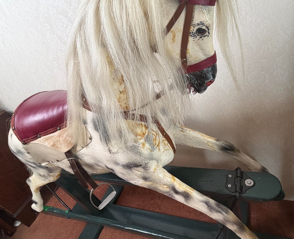 A 19th-century carved wooden dappled grey rocking horse with a leather saddle, horsehair mane, and dark green painted glider stand. View VIII
