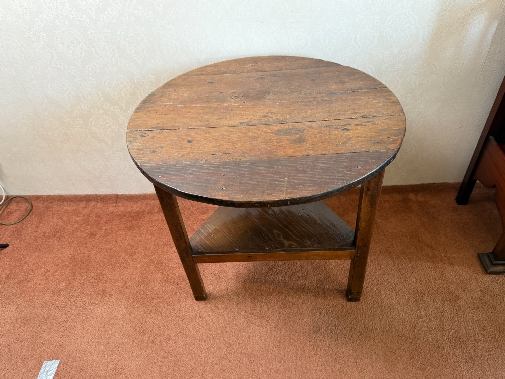 A late 18th-century dark oak cricket table featuring a circular top, three square-tapered legs, and a triangular lower shelf. View II