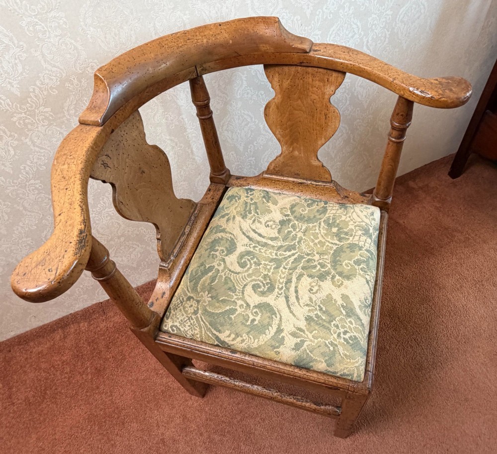 An 18th-century oak corner chair featuring turned supports, two vase-shaped back splats, a curved top rail, and a patterned green fabric drop-in seat. View IV