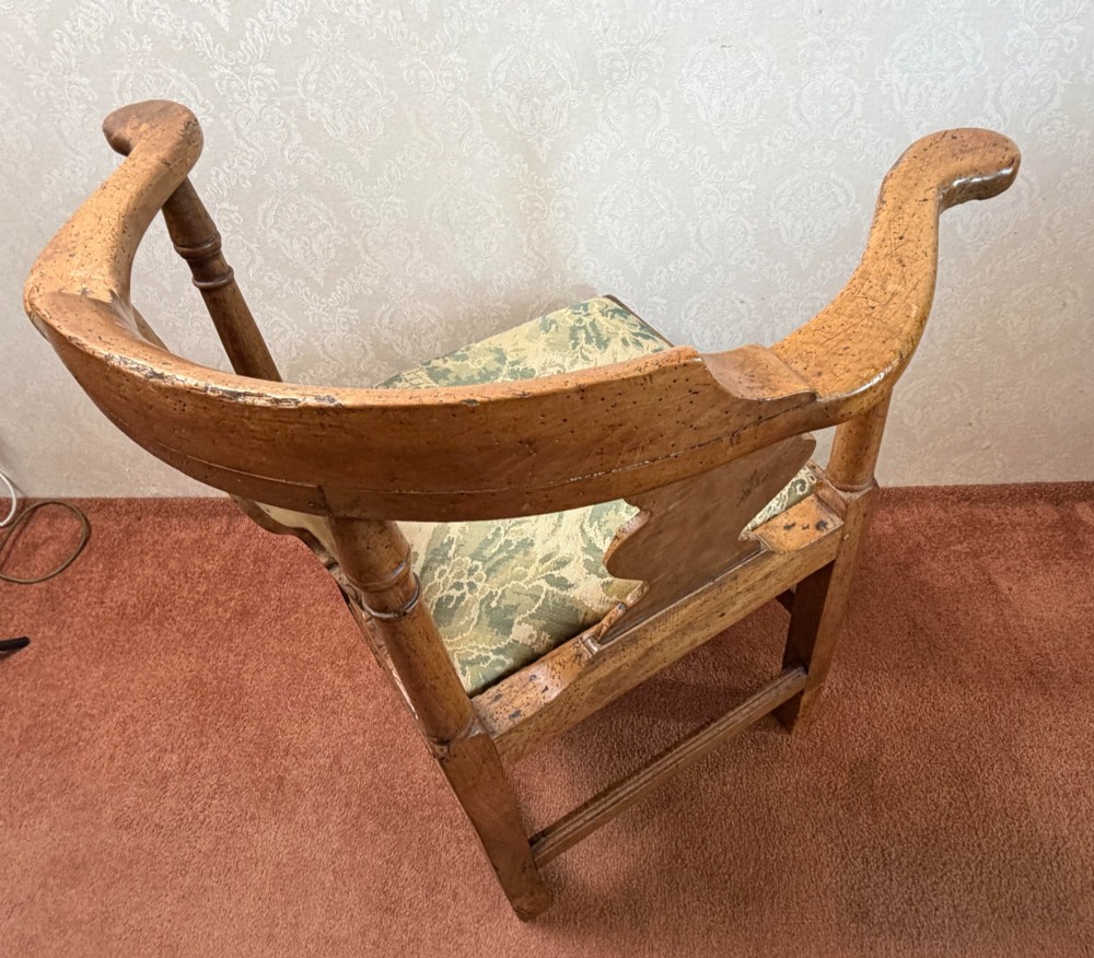An 18th-century oak corner chair featuring turned supports, two vase-shaped back splats, a curved top rail, and a patterned green fabric drop-in seat. View V