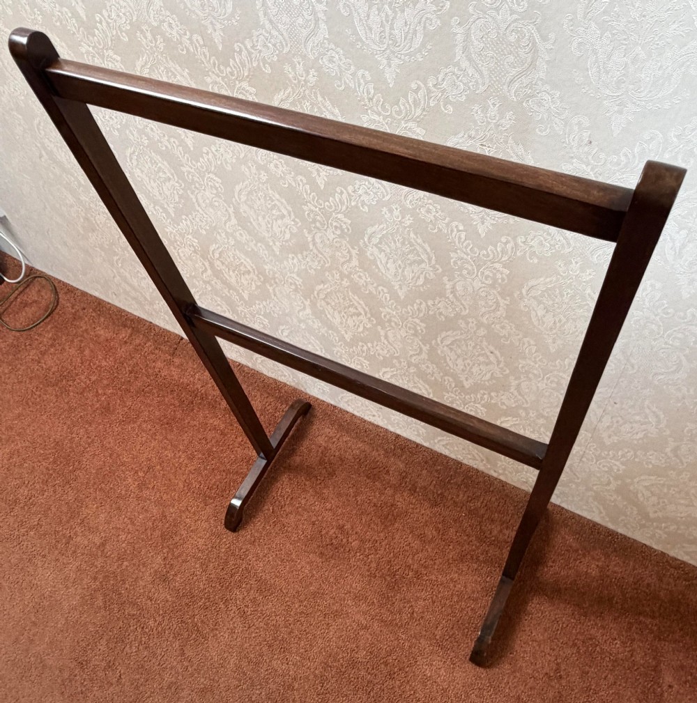 An early nineteenth-century dark mahogany freestanding towel rail featuring two horizontal crossbars supported by vertical uprights and sledge feet. View II