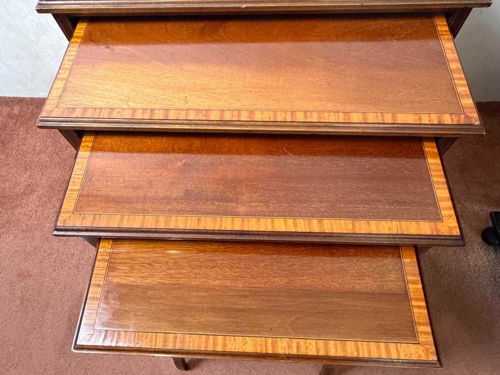 A set of four nesting mahogany tables featuring rectangular tops with satinwood crossbanding and square tapered legs. View III