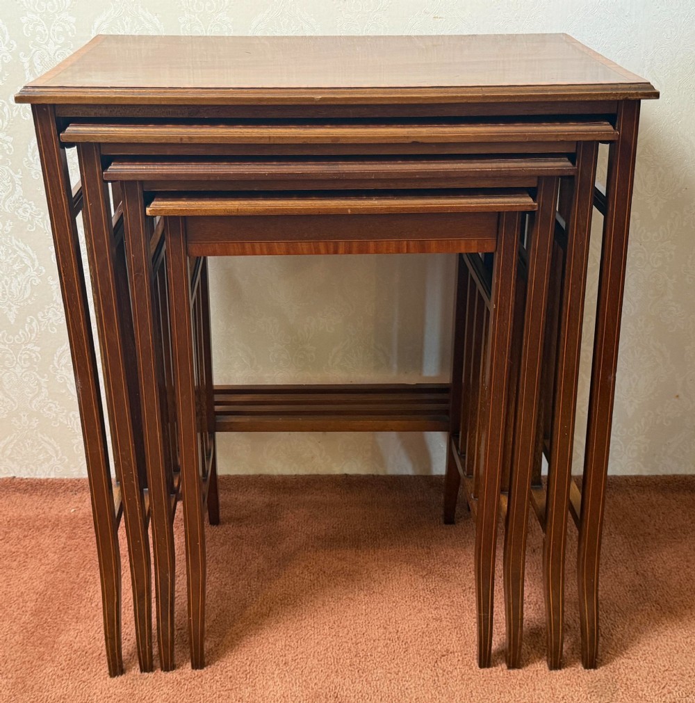 A set of four nesting mahogany tables featuring rectangular tops with satinwood crossbanding and square tapered legs. View IV