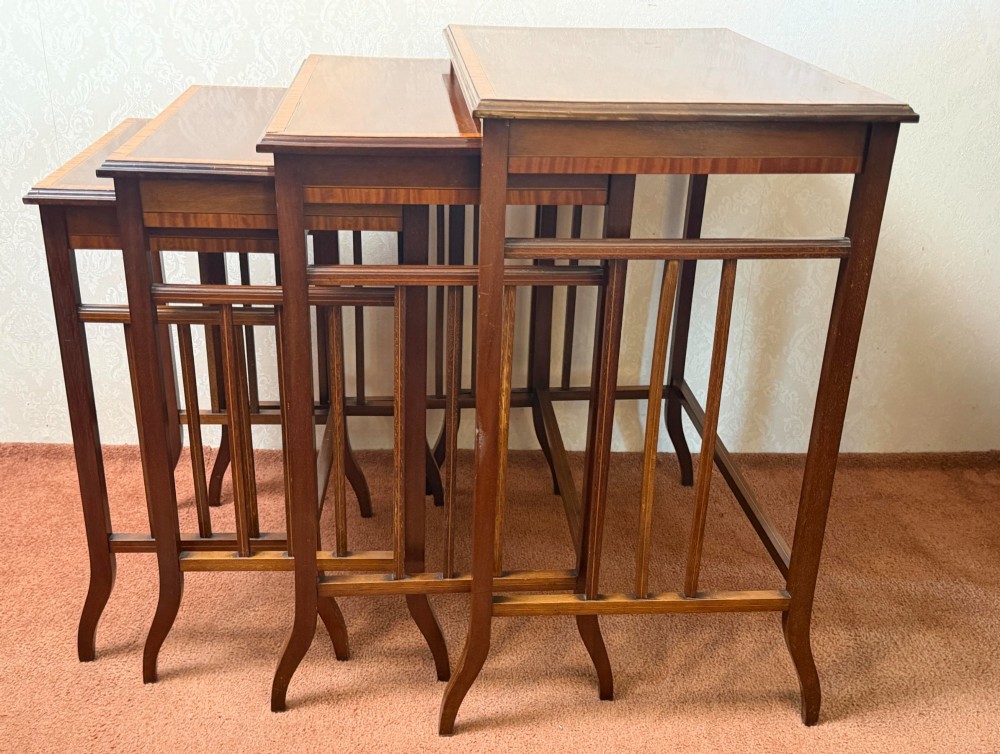 A set of four nesting mahogany tables featuring rectangular tops with satinwood crossbanding and square tapered legs. View VI