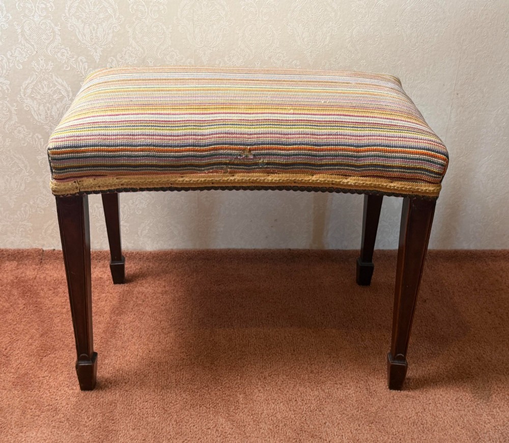 A late 18th-century mahogany stool with square tapering legs and a seat upholstered in multi-coloured vertical striped fabric with braided trim. View II