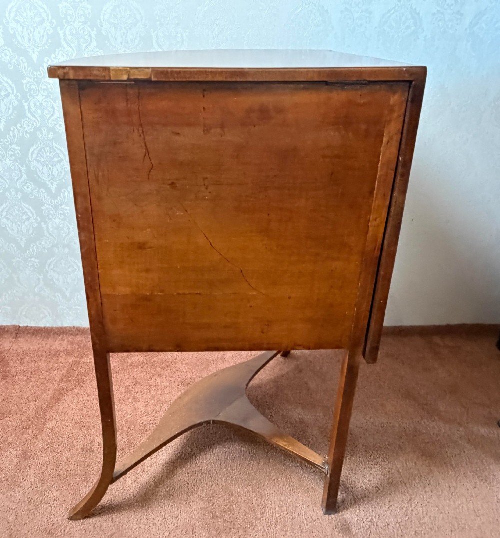 A Georgian satinwood corner washstand with dark timber crossbanding, a central cupboard door, and splayed legs. View VII