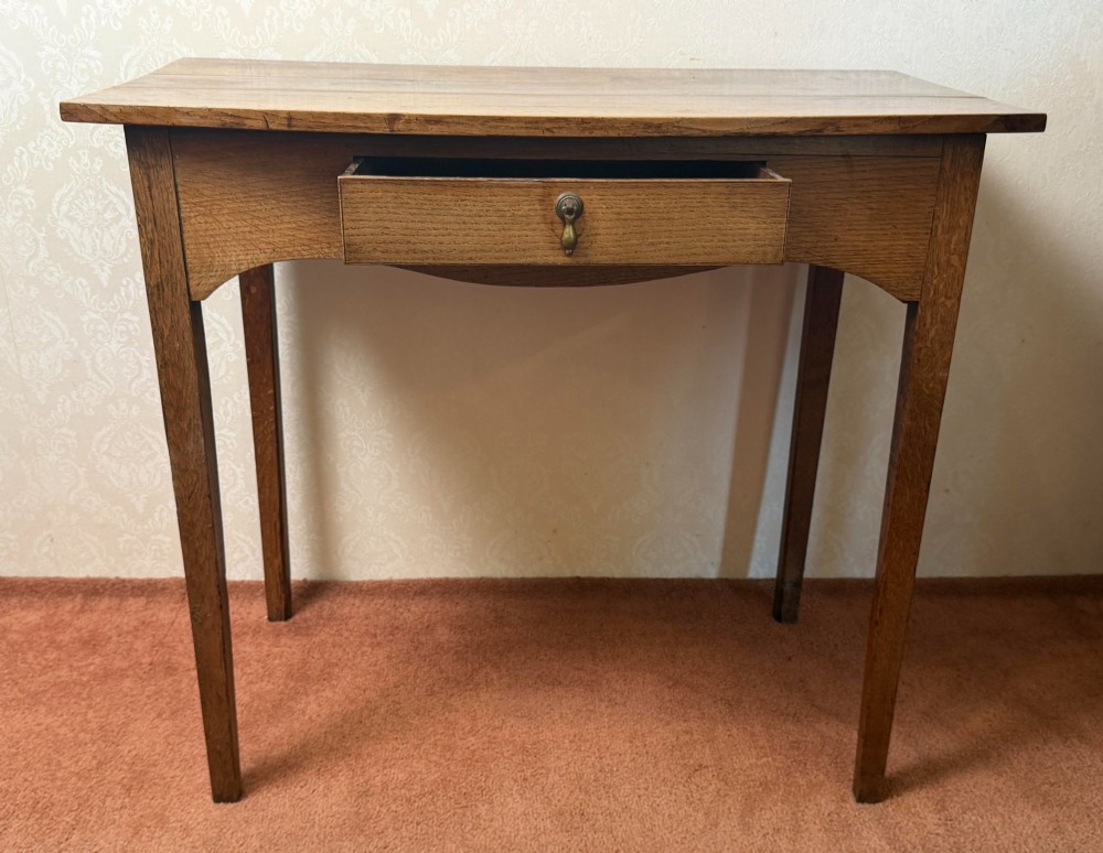 An antique oak side table featuring a single fitted drawer with a brass drop handle, a contoured apron, and four square legs. View II