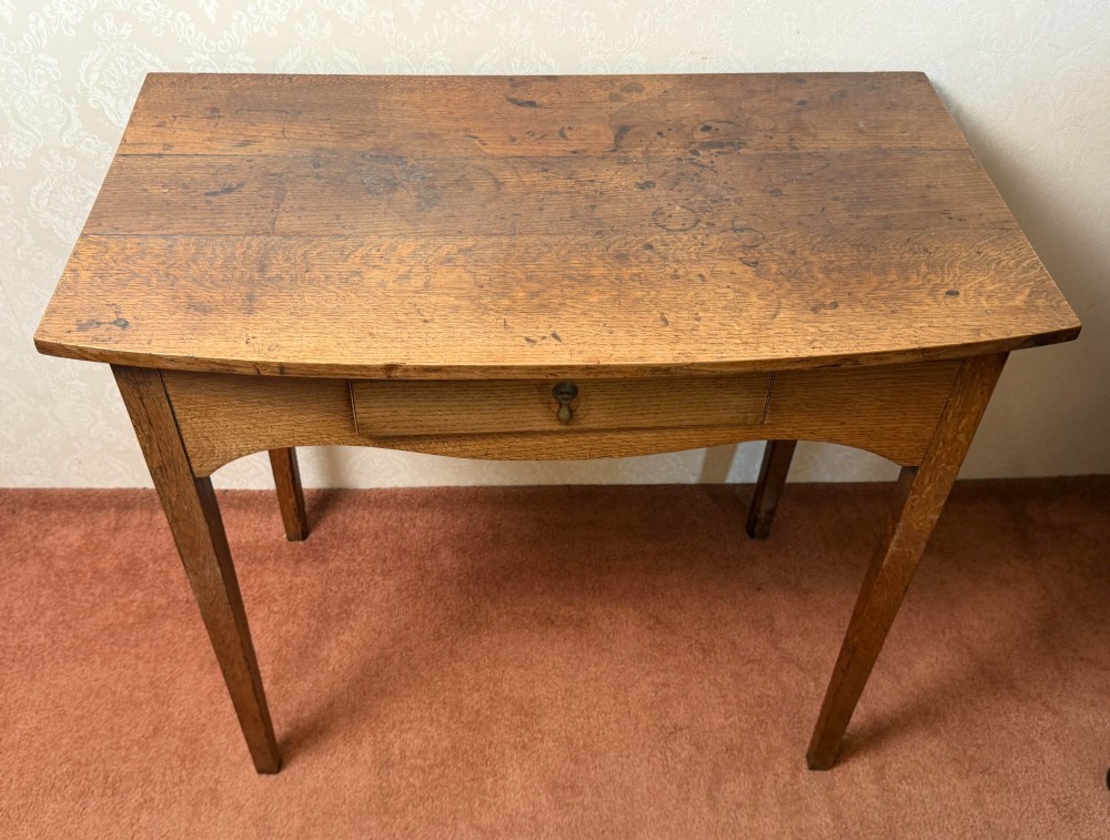 An antique oak side table featuring a single fitted drawer with a brass drop handle, a contoured apron, and four square legs. View IV
