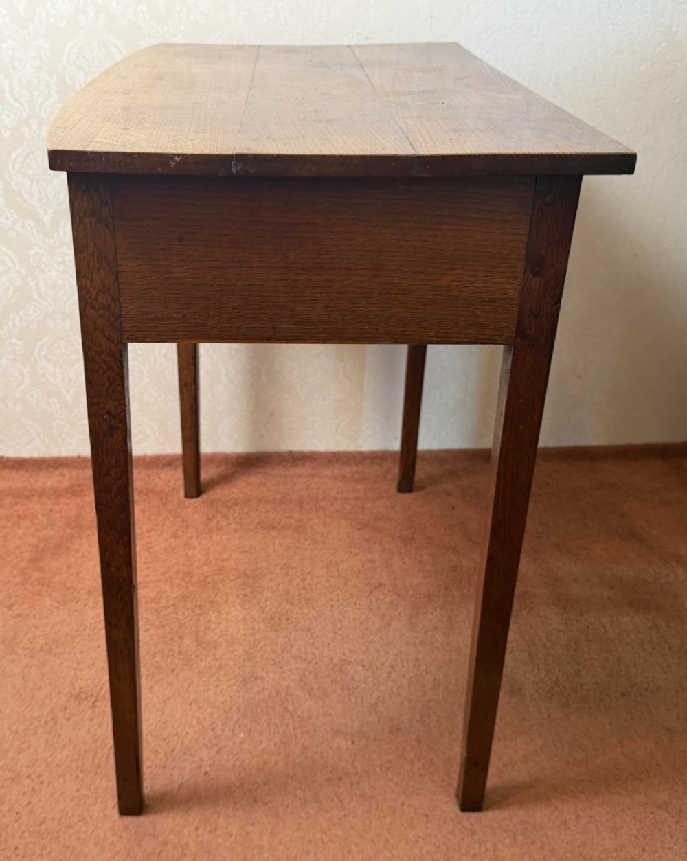 An antique oak side table featuring a single fitted drawer with a brass drop handle, a contoured apron, and four square legs. View V