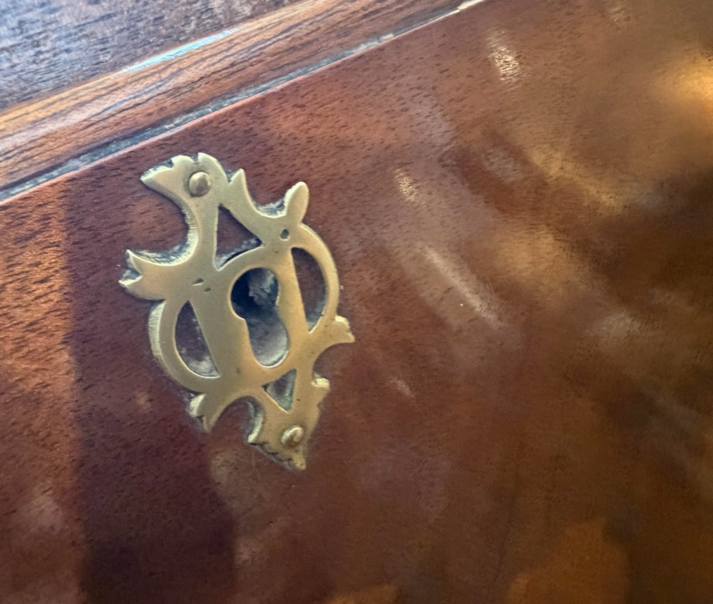 A George III mahogany bureau featuring a slant-front writing slope above two short and three long drawers with brass swan-neck handles, resting on bracket feet. View VIII