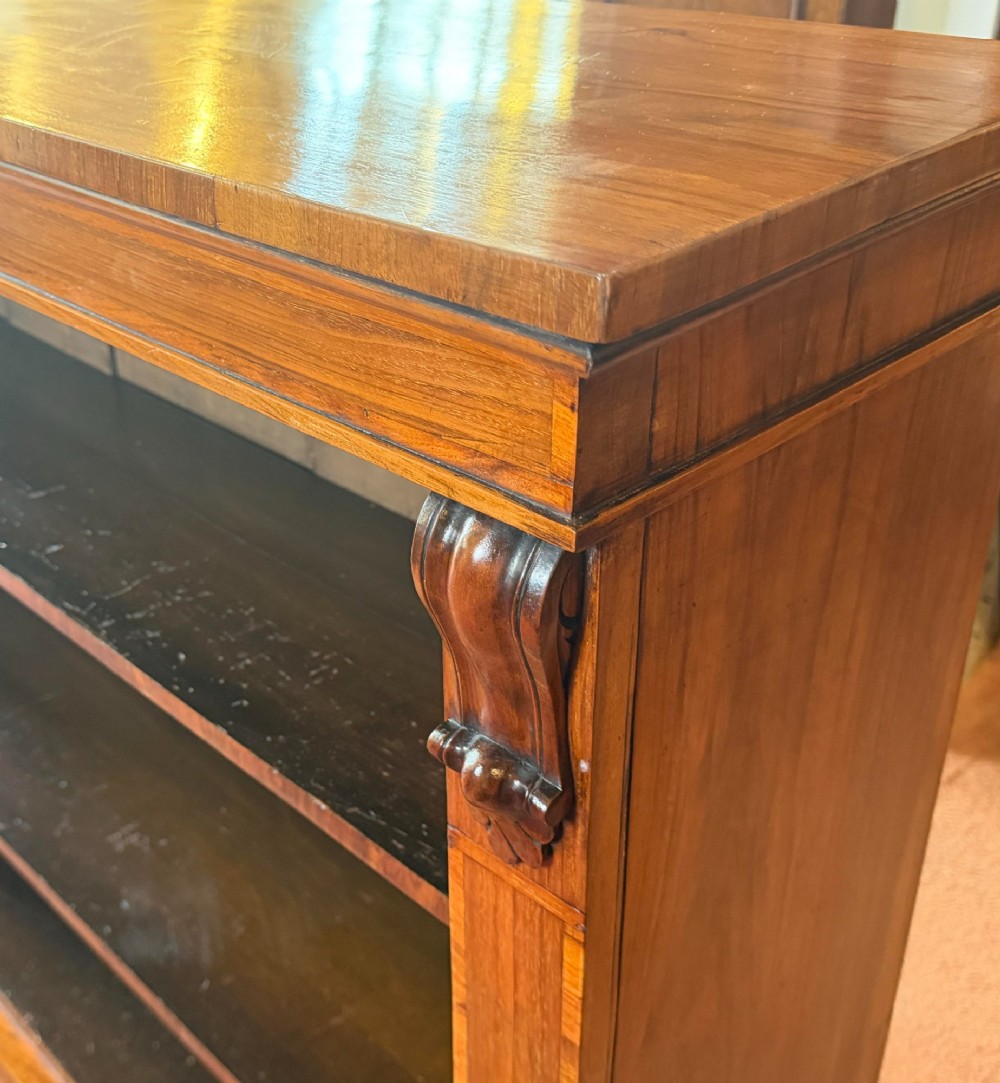 An early nineteenth-century open walnut bookcase featuring three shelves and carved corbels on the side stiles. View II
