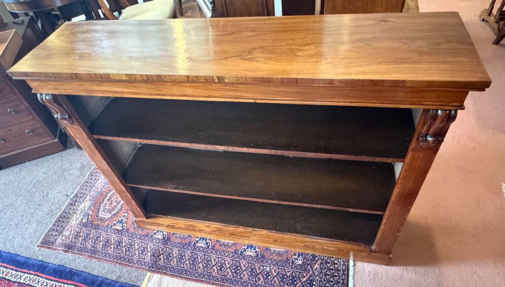An early nineteenth-century open walnut bookcase featuring three shelves and carved corbels on the side stiles. View III