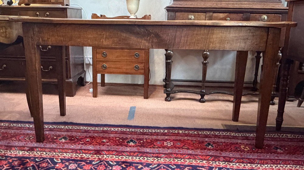 A rectangular antique wooden farmhouse table featuring a highly figured timber grain top supported by four square tapered legs. View IV