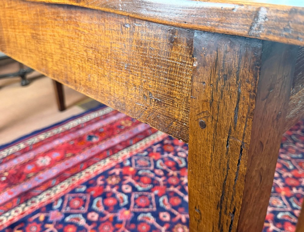 A rectangular antique wooden farmhouse table featuring a highly figured timber grain top supported by four square tapered legs. View VIII