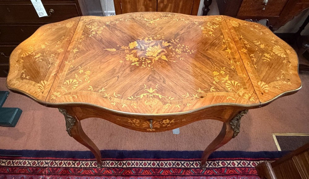 A Louis XV style walnut and kingswood side table featuring floral marquetry inlay, cabriole legs, and gilded brass mounts. View V