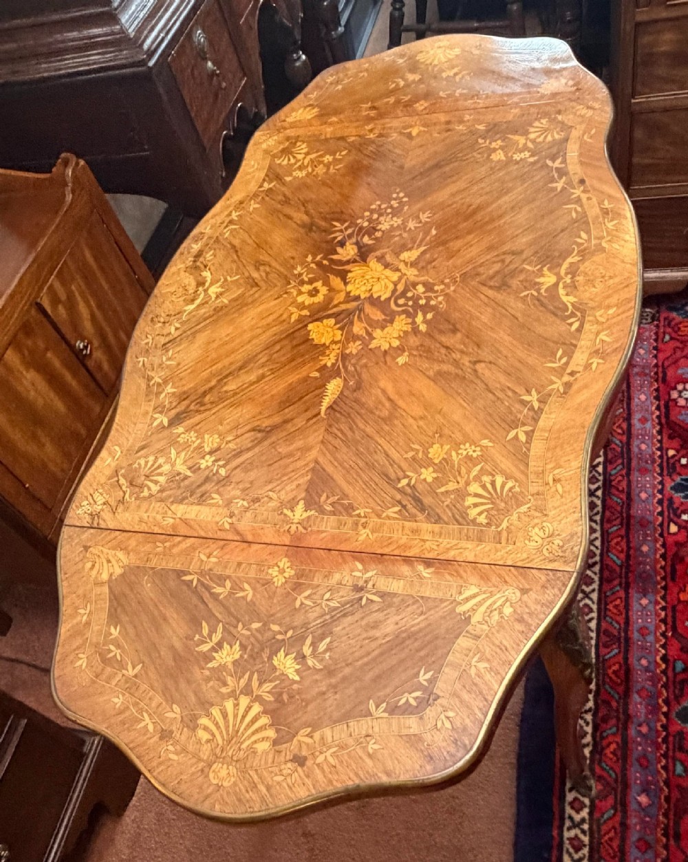 A Louis XV style walnut and kingswood side table featuring floral marquetry inlay, cabriole legs, and gilded brass mounts. View VI