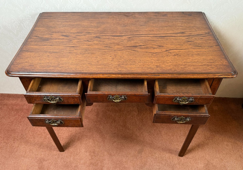 An 18th-century Georgian oak side table featuring five drawers, a central shaped apron, brass handles, and four straight legs. View III