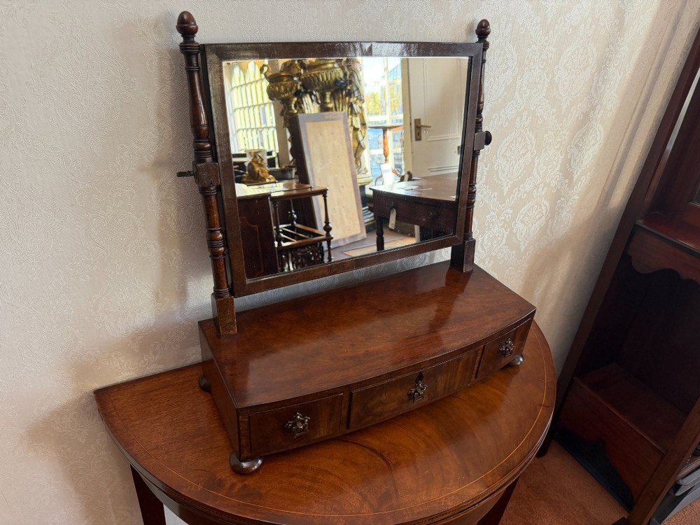 An early nineteenth-century mahogany box dressing mirror with a rectangular adjustable frame set above three drawers on small ball feet. View IV