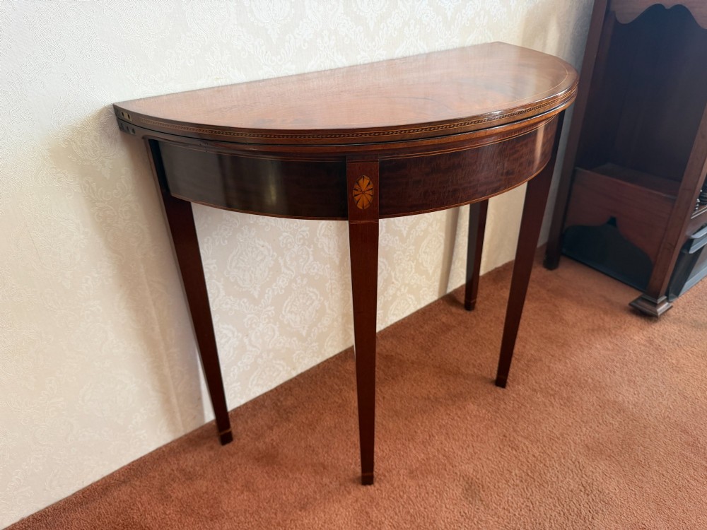 An 18th-century mahogany demi-lune card table featuring tapered legs, inlaid satinwood stringing, and a hinged fold-over top. View II
