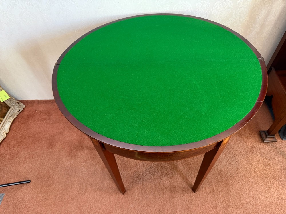 An 18th-century mahogany demi-lune card table featuring tapered legs, inlaid satinwood stringing, and a hinged fold-over top. View IV