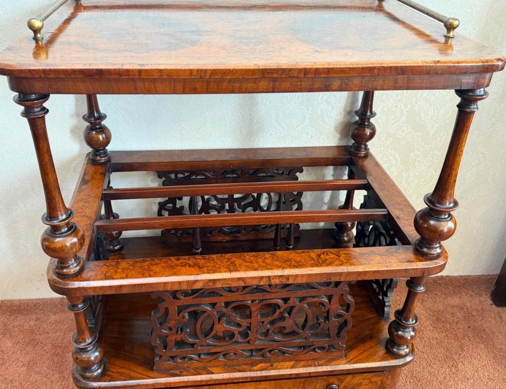 A Victorian burr walnut music Canterbury featuring a upper brass gallery rail, open vertical partitions with fretwork panels, turned corner columns, and a base drawer. View II
