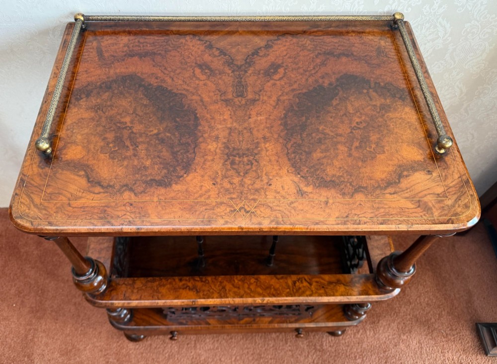 A Victorian burr walnut music Canterbury featuring a upper brass gallery rail, open vertical partitions with fretwork panels, turned corner columns, and a base drawer. View III
