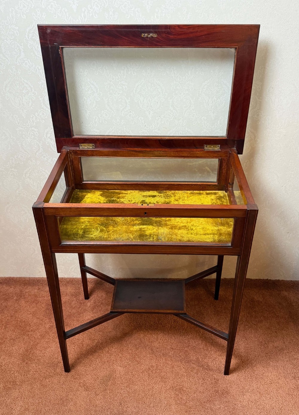 A late 19th-century mahogany bijouterie table featuring glass top and side panels, a yellow velvet-lined display interior, tapered square legs, and an X-shaped stretcher with a central undertier. View III