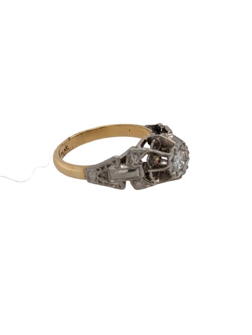 fig 1. A 1920s Art Deco solitaire ring featuring a round central diamond in a platinum setting with carved geometric shoulders on an 18ct yellow gold band.