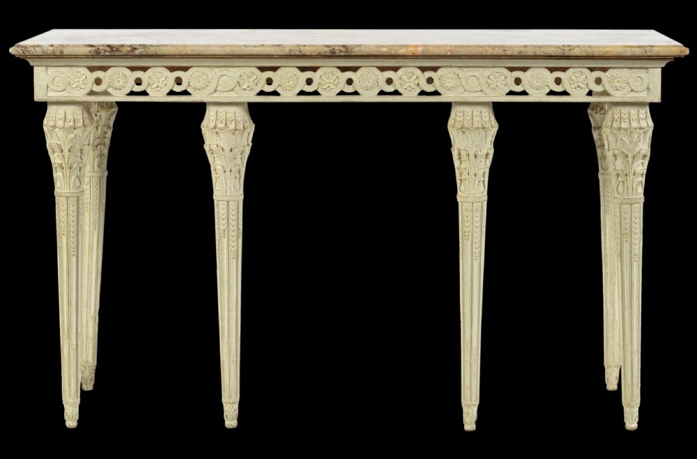 An Italian Neoclassical cream-painted console table featuring a marble top, pierced frieze with rosette carving, and four tapered fluted legs.