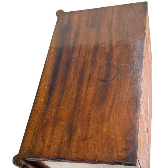 fig 3. A Regency period miniature mahogany chest featuring three graduated drawers with round knobs and reeded corner columns.